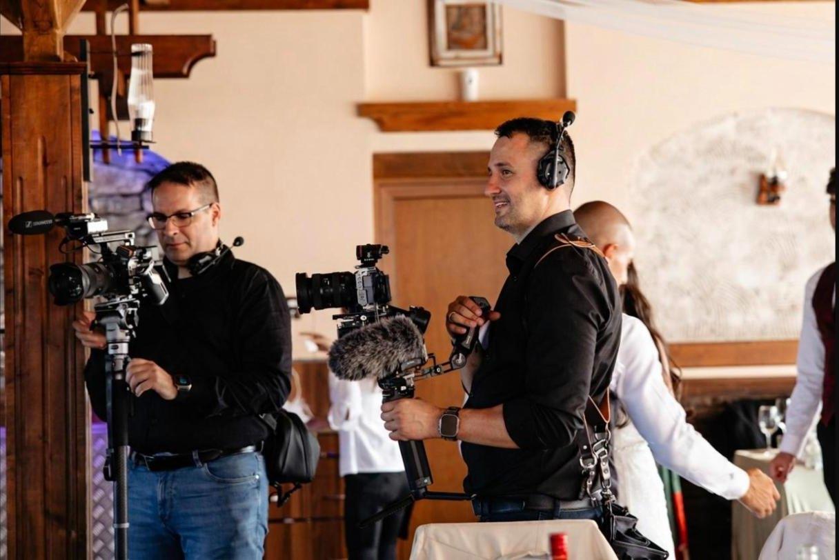 Dos fotógrafos de PhotoBros con cámaras en estabilizadores, trabajando en la fiesta de una boda